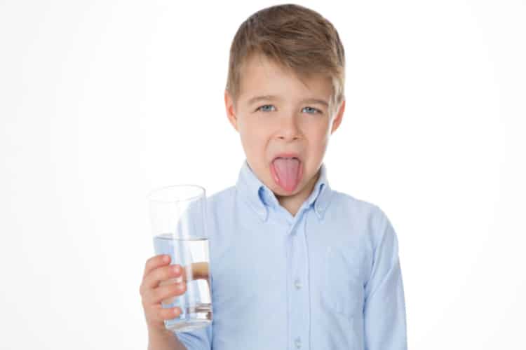 Boy holding cup with bad water